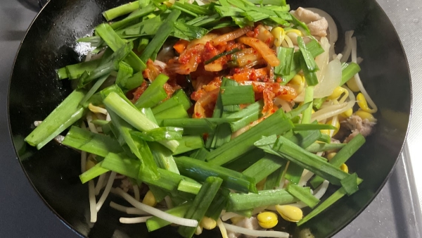 蓋を開けて、醤油を合わせ、キムチとニラを加えて炒めます。